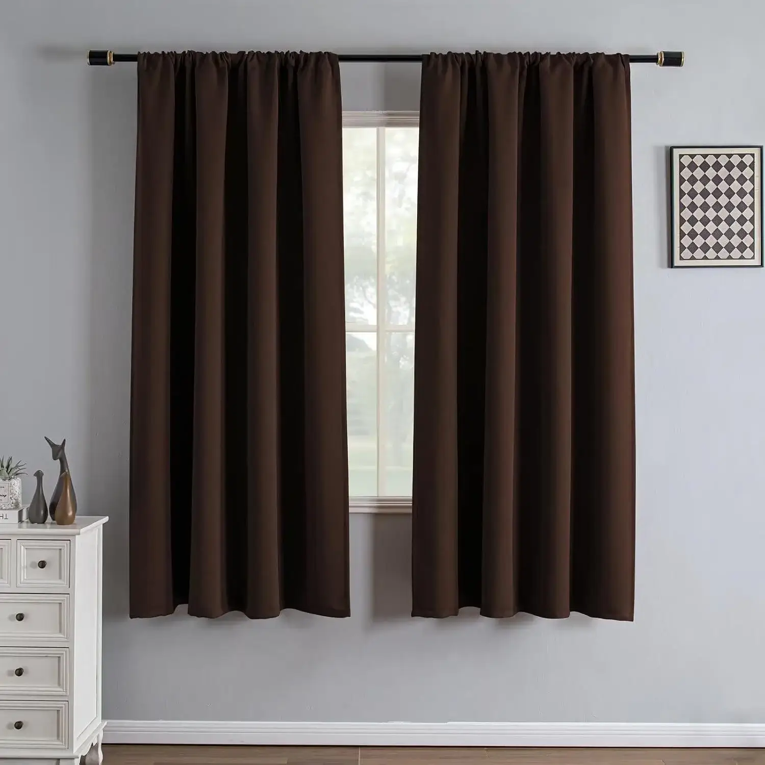 Plain dark brown curtains framing a window in a neutral-coloured room.